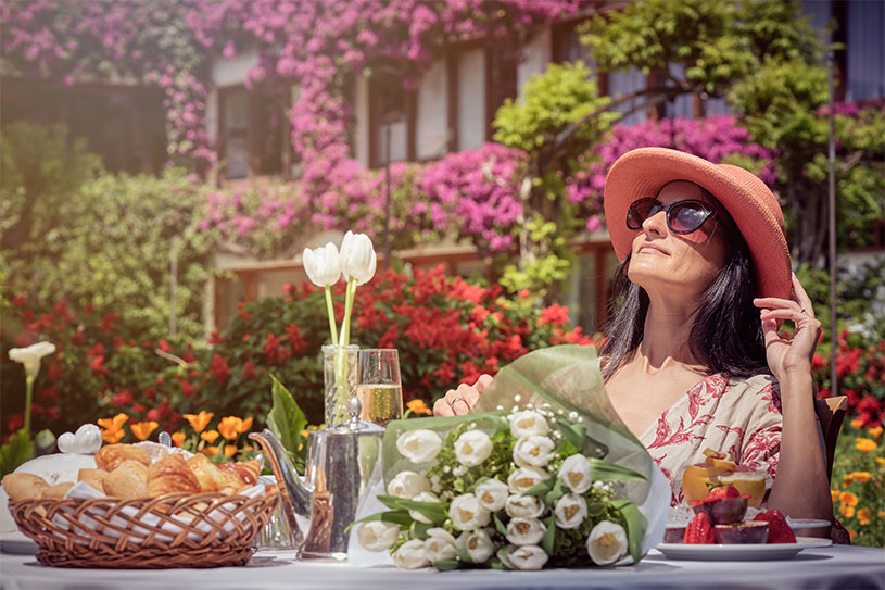 Relaxed woman enjoying the sun in beautiful flower garden